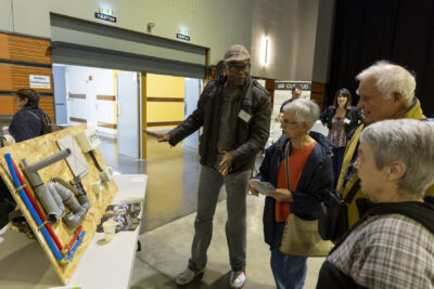 Un homme montre et explique une installation de plomberie à trois personnes âgées - Agrandir l'image 7 sur 20, fenêtre modale