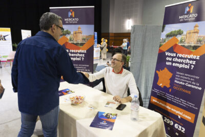 Le Maire serre la main à un homme assis à un stand "Mercato de l'emploi" - Agrandir l'image 9 sur 20, fenêtre modale