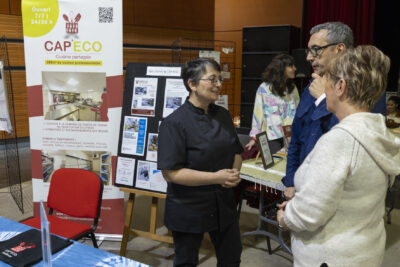 Le Maire échange avec une femme devant un stand "Cap Eco" - Agrandir l'image 20 sur 20, fenêtre modale