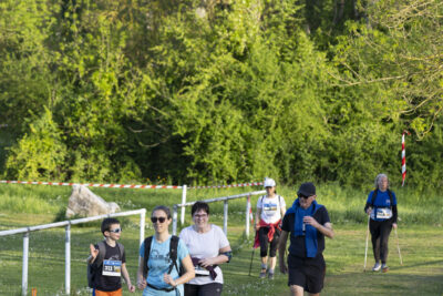 Des coureurs ainsi que des pratiquants de marche nordique sur un chemin de verdure, à côté d'une barrière blanche - Agrandir l'image 27 sur 32, fenêtre modale