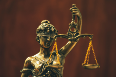 Photo d'une femme aux yeux bandés tenant d'une main un glaive et de l'autre une balance