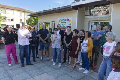 Une femme parle au micro entourée de personnes  - Agrandir l'image 10 sur 53, fenêtre modale
