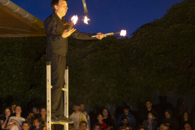 Une homme jongle avec des bâtons en feu sur une échelle - Agrandir l'image 39 sur 53, fenêtre modale