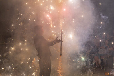 Une homme jongle avec des bâtons en feu au milieu de feu d'artifices - Agrandir l'image 51 sur 53, fenêtre modale