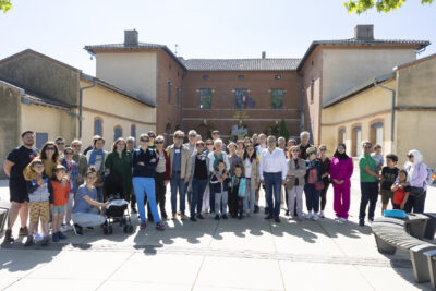 Un groupe d'une cinquantaine de personnes rassemblées avant la balade, sur le parvis de la mairie sous le soleil - Agrandir l'image 3 sur 16, fenêtre modale