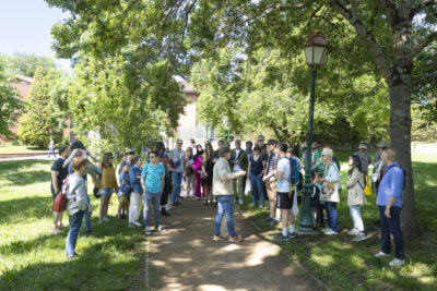 Groupes de personnes qui écoute l'élu Bruno Lombardo, dans un parc ombragé, sur un chemin piétonnier - Agrandir l'image 8 sur 16, fenêtre modale
