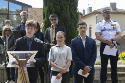 Photo d'un jeune qui parle au micro, derrière lui d'autres jeunes écoutent, leur texte à la main - Agrandir l'image 10 sur 17, fenêtre modale