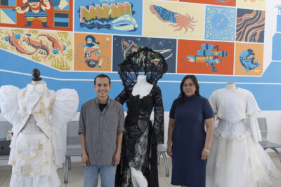 Photo portrait de tenues, robes blanches et noires sur des mannequins, avec un homme et une femme qui posent à côté - Agrandir l'image 11 sur 17, fenêtre modale