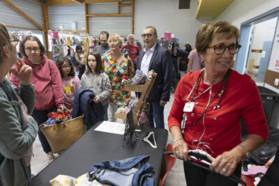 Une famille devant un stand avec un panier rempli de vêtements, le Maire Frédéric Parre et l'élue Laurence Staskiewicz à côté - Agrandir l'image 17 sur 17, fenêtre modale