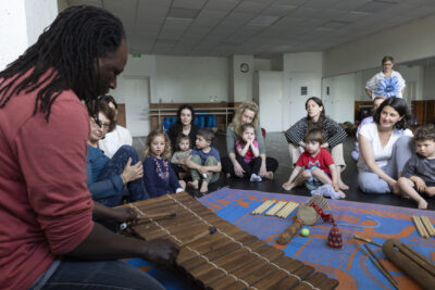 Parents et enfants qui regardent un monsieur jouer du xylophone - Agrandir l'image 9 sur 31, fenêtre modale