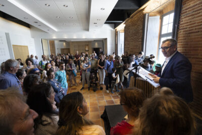 Le Maire Frédéric Parre fait un discours dans la salle du Conseil municipal, on voit plus d'une cinquantaine de personnes réunies - Agrandir l'image 1 sur 16, fenêtre modale