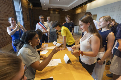 Une agent donne sa carte électorale à une jeune fille - Agrandir l'image 8 sur 10, fenêtre modale