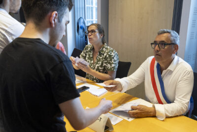 Le Maire Frédéric Parre donne sa carte électorale à un jeune homme - Agrandir l'image 6 sur 10, fenêtre modale