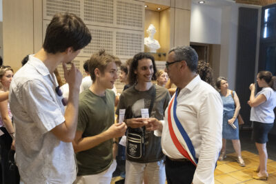 Le Maire Frédéric Parre échange avec de jeunes hommes dans la salle du conseil - Agrandir l'image 4 sur 10, fenêtre modale