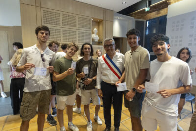 Le Maire Frédéric Parre avec un groupe de jeunes hommes qui montrent leur nouvelle carte électorale - Agrandir l'image 1 sur 10, fenêtre modale