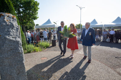 Photo du dépôt de gerbe par le Maire Frédéric Parre, l'élue Corinne Giner et un homme âgé en costume - Agrandir l'image 5 sur 5, fenêtre modale