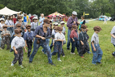 Photo du défilé du groupe d'enfants déguisés déguisés avec jean, bretelle et chemise, bérets et masque sur les yeux, avec des animateurs - Agrandir l'image 21 sur 24, fenêtre modale