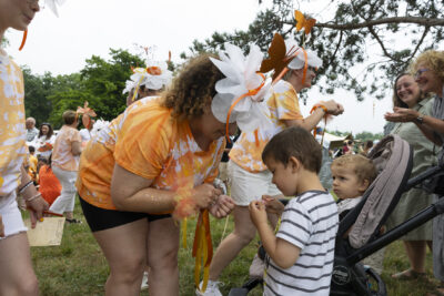 Photo d'une jeune femme qui donne des paillettes à un petit garçon - Agrandir l'image 17 sur 24, fenêtre modale