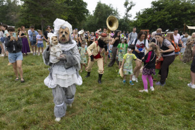 Photo de personnes en costume gris, et robes et un masque en papier mâché de créature, des enfants regardent - Agrandir l'image 13 sur 24, fenêtre modale