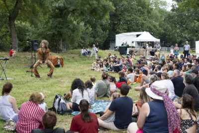 Photo paysage d'un spectacle d'un homme en costume léopard dans l'herbe devant le public dans l'herbe - Agrandir l'image 11 sur 24, fenêtre modale