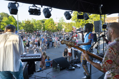 Photo paysage prise depuis une scène avec le groupe qui se produit, il y a du public rassemblé devant - Agrandir l'image 6 sur 16, fenêtre modale