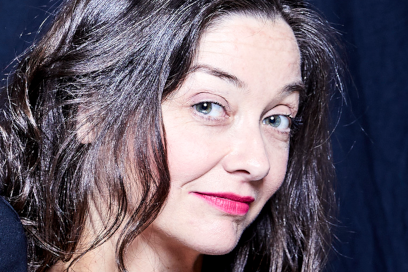 Photo en plan américain de la soliste Lina Tur Bonet de profil sourire malicieux yeux bleus et cheveux bruns brillants ondulés sur robe en dentelle noire. - Agrandir l'image, fenêtre modale