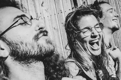 Photo noir et banc dynamique du trio de profil et en train de savourer le soleil en riant contre une palissade - Agrandir l'image, fenêtre modale