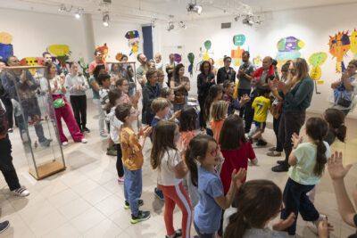 danse une salle d'expoxtion lumineuse gaiement habilée de de monstres colorés affichés aux murs, les enfants artistes s'applaudissent et les adultes rassemblés sursoient ! - Agrandir l'image 9 sur 13, fenêtre modale