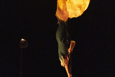 Sur la scène plongée dans la pénombre, le long d'un mât chinois surmonté d'une bulle éclairée en papier de riz, glissse une silhouette humaine comme tombée d'une autre planète, sous les yeux éberlués d'une jeune fille en arrière-plan - Agrandir l'image 1 sur 6, fenêtre modale