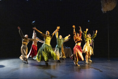 dans ce final de la pièce Mont de la Compagnie Jafarson, tous les comédiens danseurs circassiens en tenues amples et colorées aux tonalités jeune-orange-vert, se tiennent en rond, bras levés, composant un tableau vivant qui évoque un scène de fête et de liesse collective. - Agrandir l'image 6 sur 6, fenêtre modale