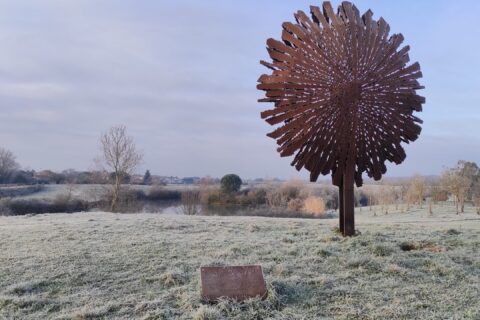 Photo du lac de l'Oustalet par temps hivernal et vue sur la sculpture en métal qui a une forme d'arbre