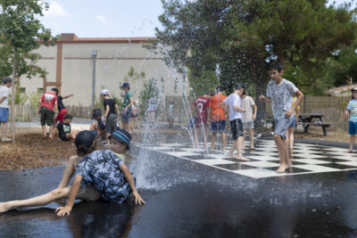 Photo d'enfants qui jouent dans une cour d'école avec des jets d'eau - Agrandir l'image 13 sur 18, fenêtre modale