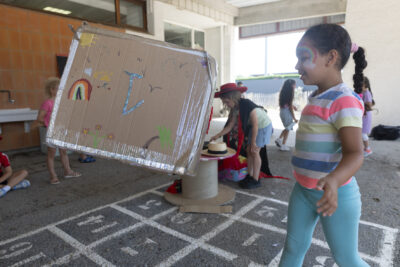 Photo d'une jeune fille avec un motif d'arc en ciel sur le visage, sous un préau - Agrandir l'image 7 sur 18, fenêtre modale