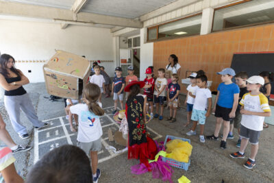 Photo d'enfants rassemblés dans une cour d'école, un enfant tient un dé géant fabriqué en carton - Agrandir l'image 5 sur 18, fenêtre modale