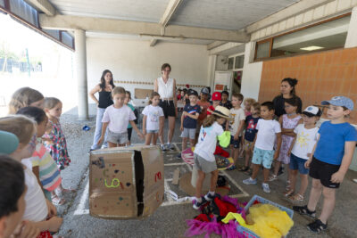 Photo d'enfants rassemblés dans une cour d'école, un enfant tient un dé géant fabriqué en carton - Agrandir l'image 4 sur 18, fenêtre modale