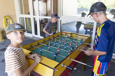 Photo de trois jeunes garçons qui jouent au babyfoot - Agrandir l'image 2 sur 18, fenêtre modale