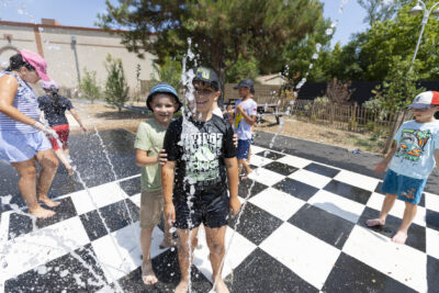 Photo de deux enfants devant des jets d'eau qui sortent du sol - Agrandir l'image 18 sur 18, fenêtre modale