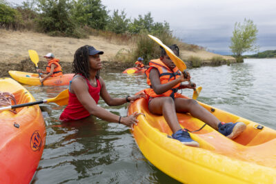 Photo d'un animateur qui tient le kayak d'une jeune fille - Agrandir l'image 2 sur 16, fenêtre modale