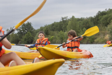 Photo de jeunes garçons sur leurs kayaks en train de ramer
