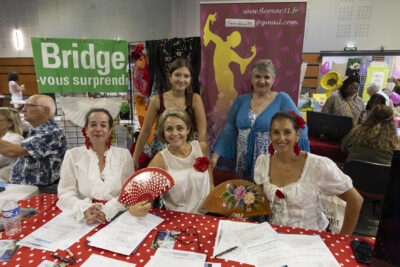photo du stand florear avec cinq femmes derrière qui sourient à l'objectif, trois d'entre elles portent un haut blanc et tiennent un éventail ouvert à la main - Agrandir l'image 64 sur 68, fenêtre modale