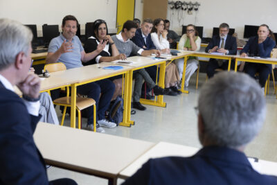 Photo d'une réunion dans une salle de classe, les tables disposées en cercle, un homme en train de parler - Agrandir l'image 7 sur 80, fenêtre modale