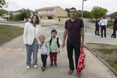 une famille avec deux enfants debout sur le trottoir sourient à l'objectif - Agrandir l'image 43 sur 80, fenêtre modale