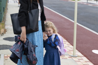 une femme avec sa fille qu'elle tient par la main, elles sont sur le trottoir à côté d'une piste cyclable, tout sourire - Agrandir l'image 53 sur 80, fenêtre modale