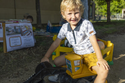 Photo d'un petit garçon sur un mini tracteur, en extérieur au soleil - Agrandir l'image 16 sur 16, fenêtre modale