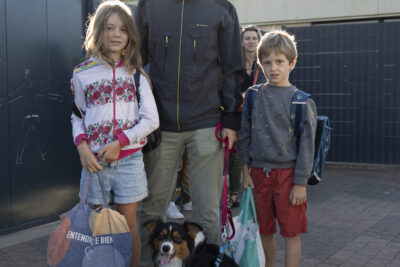Photo d'un père avec ses deux enfants, un de chaque côté, et un chien devant qui pose avec eux - Agrandir l'image 2 sur 80, fenêtre modale