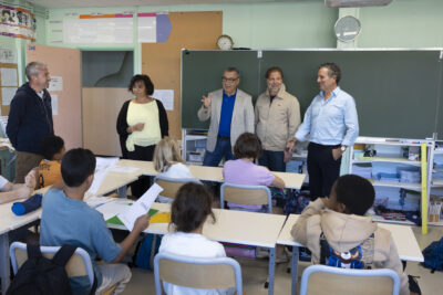 Photo dans une salle de classe, les élèves sont assis à leurs pupitres, le Maire est avec d'autres élus devant - Agrandir l'image 28 sur 80, fenêtre modale