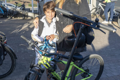 Photo d'une femme et son fils, qu'elle tient par l'épaule, devant un vélo et une trottinette électrique - Agrandir l'image 22 sur 80, fenêtre modale