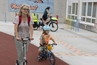 Une femme à trottinette sur la piste cyclable rouge avec une petite fille à vélo - Agrandir l'image 35 sur 80, fenêtre modale