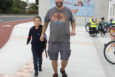 Un père et son fils marchent en direction de l'objectif en souriant - Agrandir l'image 32 sur 80, fenêtre modale