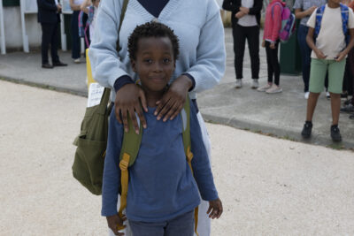 une femme et son fils, elle est derrière lui et les mains sur ses épaules, ils sourient - Agrandir l'image 63 sur 80, fenêtre modale
